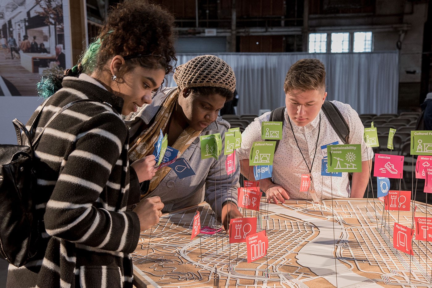 Group of people leaning over a large 3D map of portland